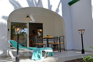 a patio with an archway with chairs and a table at Ferienwohnung PRESIDENTE - Pool - Glasfaserinternet - Costa Calma in Costa Calma