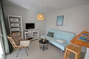 a small living room with a blue couch and a chair at Ferienwohnung PRESIDENTE - Pool - Glasfaserinternet - Costa Calma in Costa Calma