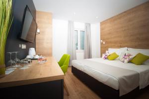 1 dormitorio con 1 cama con escritorio y silla verde en Ora Luxury Rooms, en Dubrovnik