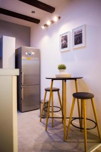 einen Tisch und zwei Hocker neben einem Kühlschrank in der Unterkunft Luxurious apartment with private garden in Split