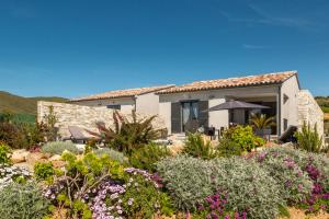 a house with a garden with flowers and plants at Le Domaine De Marie in Palasca