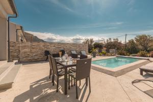 a patio with a table and chairs next to a swimming pool at Le Domaine De Marie in Palasca