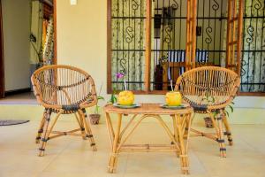 two chairs and a table with fruit on top of it at CASA VACANSA HOME STAY in Hungama