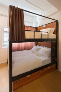 2 literas en una habitación con sábanas blancas en 7 Wonders Hostel at Upper Dickson en Singapur