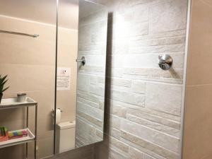 La salle de bains est pourvue d'une douche avec une porte en verre. dans l'établissement La Vie En Rose Studio,close to beach, Paleo Faliro, à Athènes