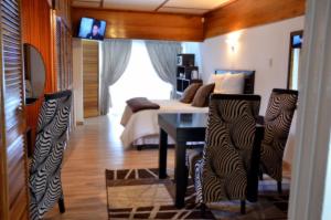 - une chambre avec un lit, une table et des chaises dans l'établissement Azrielle Guesthouse, à Sasolburg
