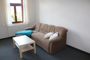 sala de estar con sofá marrón y mesa en Ferienwohnung Post, en Ottendorf-Okrilla