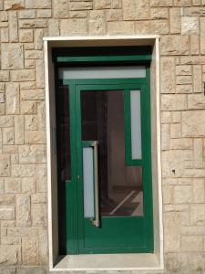 una porta verde in un muro di mattoni di GASCON7.4 a Teruel