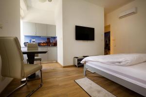 a bedroom with a bed and a desk with a chair at Metropolis Apartments in Zagreb
