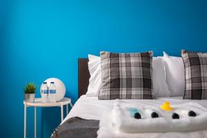 a bedroom with a bed with a blue background at Lloyd Close Cheltenham - Close to Town Centre & GCHQ in Cheltenham