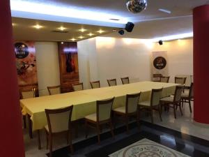 un comedor con una mesa larga y sillas en Bolero Hotel, en Ferizaj