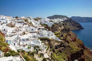 Vue aérienne d'une ville sur le côté d'une montagne dans l'établissement Ifestio Villas Oia, à Oia