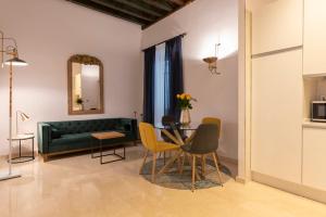 sala de estar con sofá verde, mesa y sillas en San Jerónimo 17 Suites, en Granada 50 fotos más