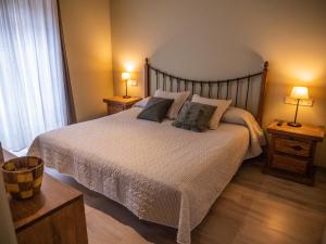 Un dormitorio con una cama grande con almohadas. en Peira Blanca Hotel Gastronómico en Garós