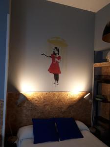 una pintura de una mujer en una pared sobre una cama en Hostal Hispalense, en Madrid