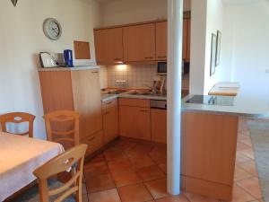 eine Küche mit Holzschränken und einem Tisch und Stühlen in der Unterkunft Ferienwohnung Mönchgut 1 mit Wintergarten und Terrasse in Ostseebad Sellin