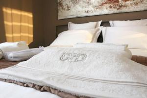 uma cama com cobertores brancos e almofadas em B2B Luxury Apartments Hotel Services Included em Knokke-Heist