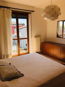 een slaapkamer met een groot bed en een groot raam bij APPARTAMENTO PESCHIERA - zona Ospedale Pederzoli in Peschiera del Garda