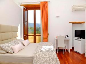 um quarto com uma cama, uma secretária e uma janela em B&B Villa Elisa em Meta