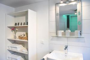 a white bathroom with a sink and a mirror at Ferienwohnungen zur Elz in Kappel-Grafenhausen +35 photos