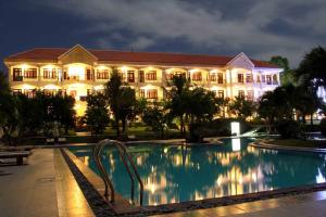 a large building with a swimming pool in front of it at Muine Century Beach Resort & Spa in Mui Ne