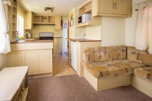 a kitchen and living room with a couch and a table at Mobile homes Marina Liptov in Bešeňová