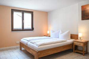 a bedroom with a bed with two lamps on tables at Ferienwohnungen zur Elz in Kappel-Grafenhausen