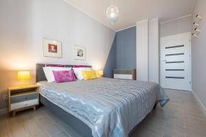 ワルシャワにあるRaya Mansion Warsawのベッドルーム1室(ピンクと黄色の枕が付いたベッド1台付)