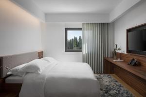 a bedroom with a bed and a flat screen tv at Hotel Milan in Pula