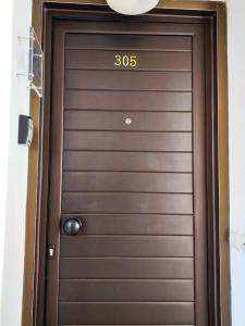 Una puerta marrón con el número. en Detrinver in Albufeira 305, en Albufeira