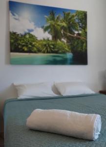 una toalla en una cama con una foto en la pared en Detrinver in Albufeira 305, en Albufeira
