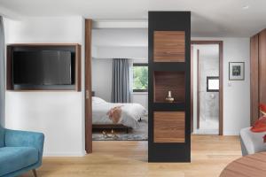 a bedroom with a bed and a tv in a room at Hotel Milan in Pula