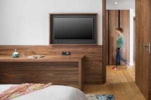 a person standing in a room with a television at Hotel Milan in Pula