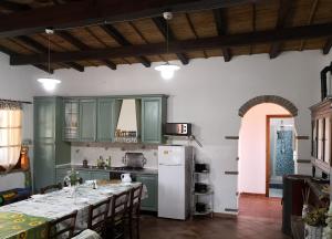 a kitchen with green cabinets and a white refrigerator at Villa L'Oleandro in Oliena