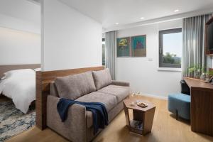 a living room with a couch and a bed at Hotel Milan in Pula
