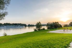 Un groupe de gens jouant au football sur la rive d'un lac dans l'établissement Camping & Pension Au an der Donau, à Au an der Donau