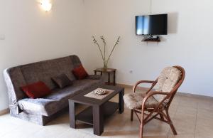 een woonkamer met een bank, een tafel en een stoel bij Apartments Krivokapic Prcanj with Bay view in Kotor