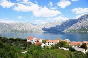 een stad aan de oever van een meer met bergen bij Apartments Krivokapic Prcanj with Bay view in Kotor