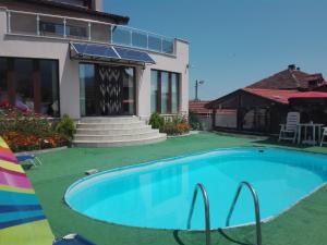 a swimming pool in front of a house at Guest House Camellia in Berkovitsa