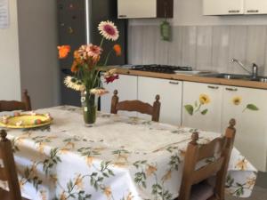 una cucina con tavolo e vaso di fiori di Linda's home a Terzigno