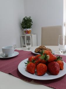 a plate of strawberries and cookies on a table at Pineta25 in Pula +14 photos