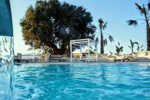 a swimming pool with a gazebo in the background at Agriturismo I Pozzetti in Savelletri di Fasano +38 photos