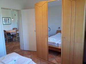 ein Schlafzimmer mit einem Schrank mit einem Bett und einem Spiegel in der Unterkunft Ferienwohnung Mönchgut 1 mit Wintergarten und Terrasse in Ostseebad Sellin + 37 Fotos