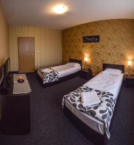a hotel room with two beds and a television at Elite Spetema Hotel in Sofia
