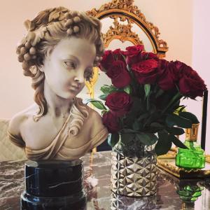 a statue of a bust next to a vase of roses at Palazzo dei Grifoni - Luxury Suites - in San Benedetto del Tronto