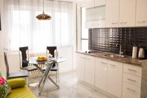 a kitchen with a table and a dining room at Golden Mirror Apartment in Novi Sad