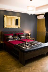 a bedroom with a large bed with a gold mirror at Golden Mirror Apartment in Novi Sad