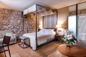 a bedroom with a bed and a stone wall at Parador de Alarcón in Alarcón