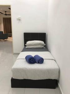 - un lit avec 2 serviettes bleues dans l'établissement NZAK Homestay, Bukit Bandaraya Seksyen U11, à Setia Alam