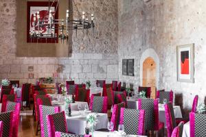 a dining room with tables and chairs and a chandelier at Parador de Alarcón in Alarcón +39 photos